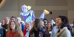 A giant NOFA puppet parades through the Winter Conference crowd.